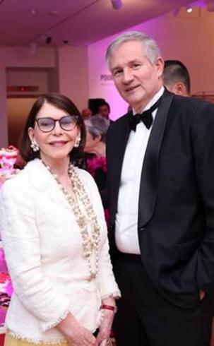 Photograph of two people in black tie standing together smiling at the camera