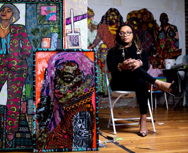 Zsudayka Nzinga sitting in her studio surrounded by her artwork