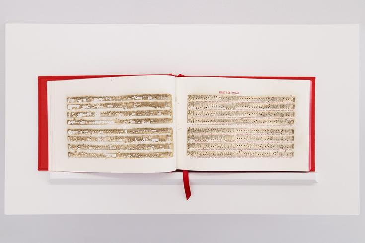 Photograph of an open hymnal book with a red cover