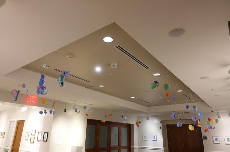 Mobiles with paper mache shapes, displayed from the ceiling.