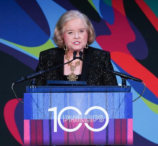 Photograph of a person speaking at a podium