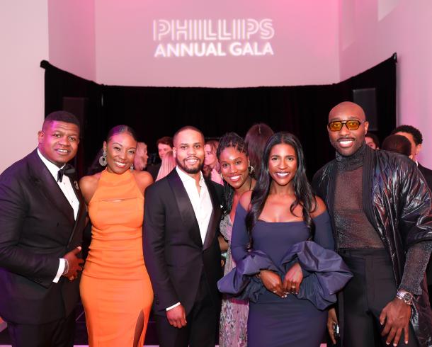 Photograph of six people in black tie standing together smiling at the camera