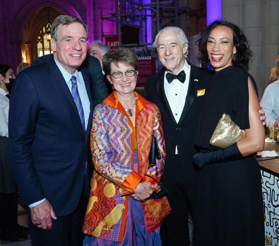 Photograph of four people in black tie standing together smiling at the camera